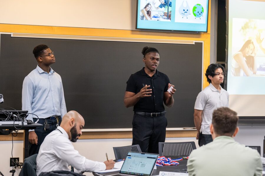 New Mission High School seniors Darareaksmey Chhim (from left), Mario Fils, and Dorian Planto pitching their plastic-eating bacteria concept at BU’s Biological Design Center’s Synthetic Biology Shark Tank Competition April 26.